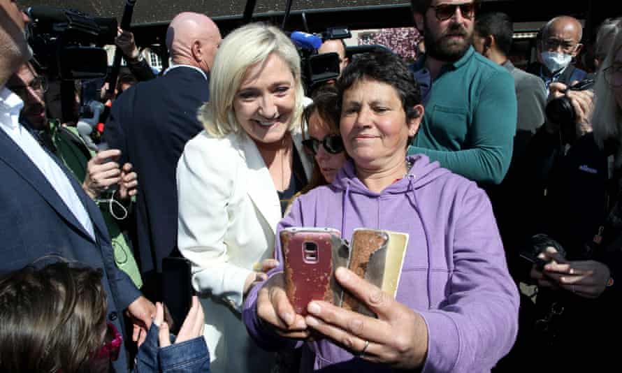 Marine Le Pen pose pour une photo avec un membre du public lors d'une visite de campagne à Saint-Remy-sur-Avre, dans le nord-ouest de la France, samedi.