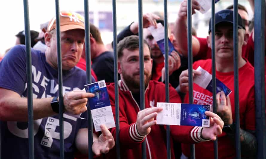 Les fans de Liverpool bloqués à l'extérieur du terrain montrent leurs billets de match.