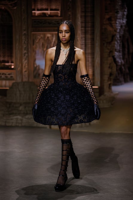 Un mannequin en robe noire à cerceaux sur le podium de Dior à Paris.